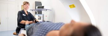 Pflegekraft bereitet Patient auf Knochendichtemessung vor