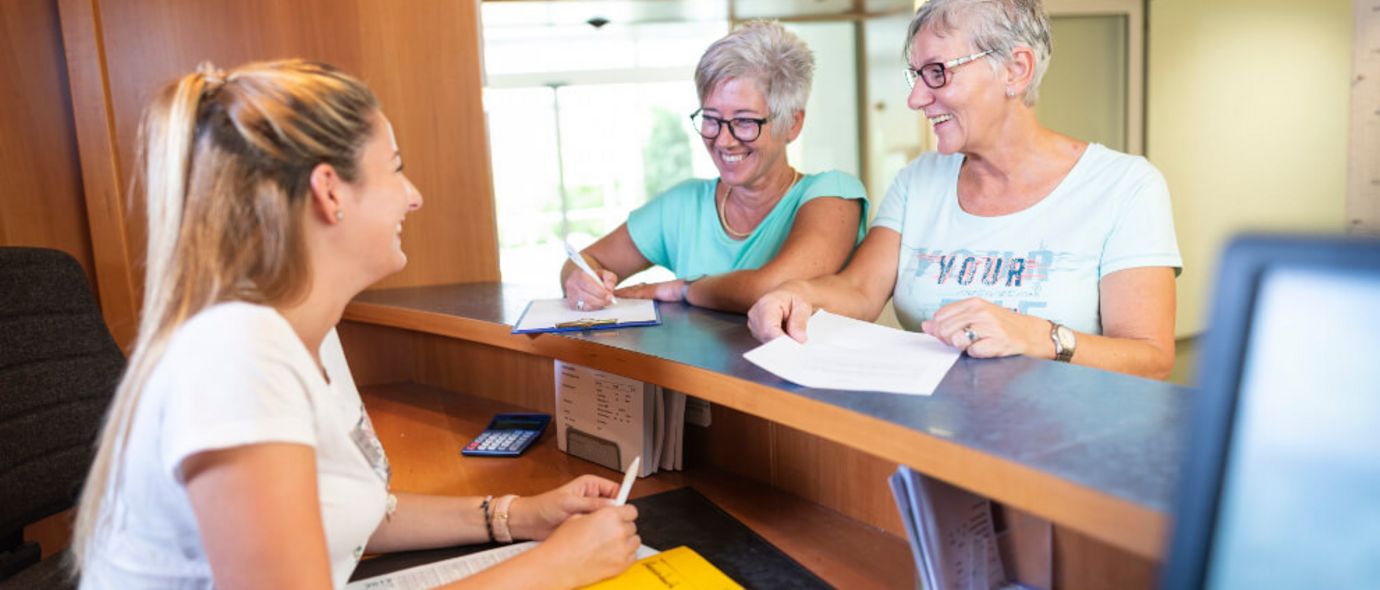 Patientinnen melden sich an der Rezeption an