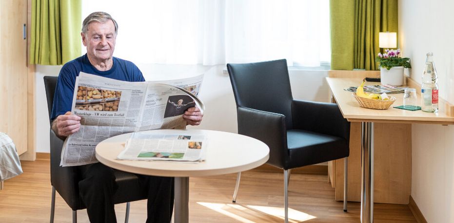 Patient liest Zeitung in seinem Zimmer