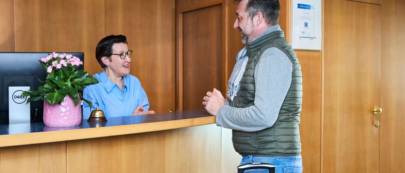 Patient checkt am Klinik-Empfang ein