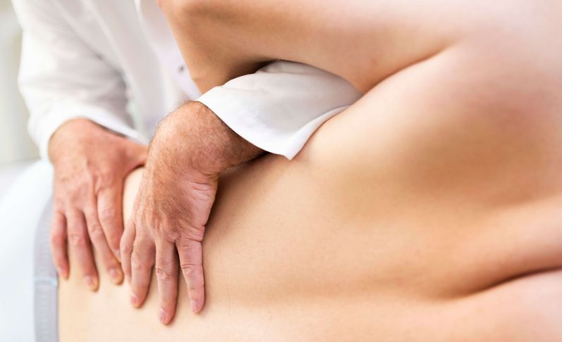 Arzt untersucht Rücken eines Patienten