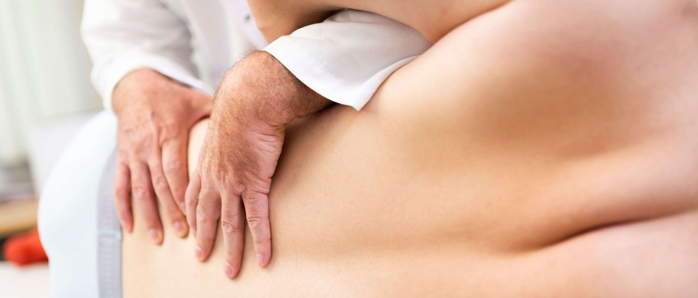 Arzt untersucht Rücken eines Patienten