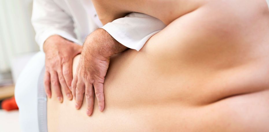 Arzt untersucht Rücken eines Patienten